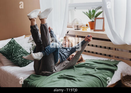 Cheerful little boy having fun with mother on sofa Stock Photo