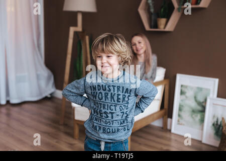 Happy mother's day. Child son congratulates mom and gives her postcard. Mum and son miling and hugging. Stock Photo