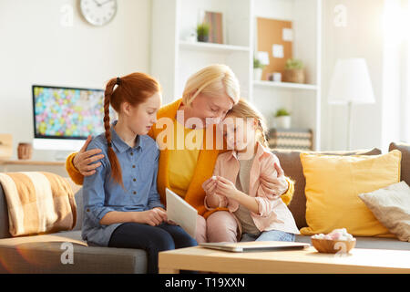 Mature Mother Embracing Two Girls Stock Photo