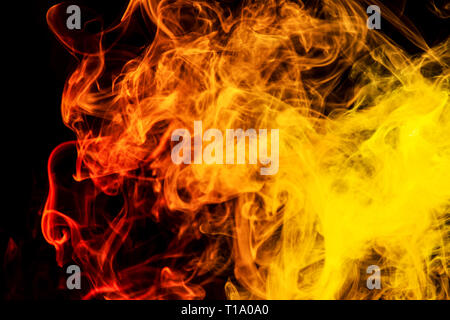 Colorful orange and yellow smoke  on a black isolated background. Background from the smoke of vape Stock Photo