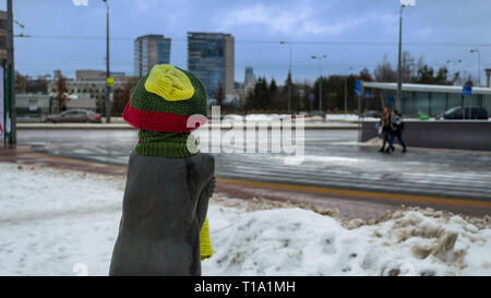 A statue of a girl wearing a yellow green and red cap and a scarf on a cold and windy winter day looking to the distance Stock Photo