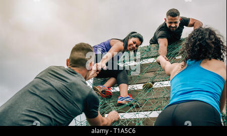 Participants in obstacle course climbing net Stock Photo