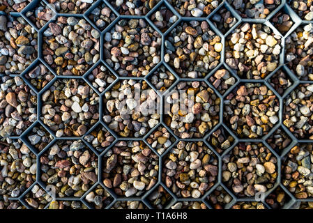 Plastic mat filled with colorful pebbles, Illuminated gently with sunlight. Stone background. Stock Photo