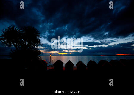 storm,dramatic,sunset,over,sea,tropical,gale,palm,trees,beach,huts,the Solent,Gurnard, Isle of Wight, England, UK, Stock Photo