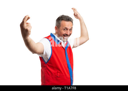 Man with excited expression working at supermarket or hypermarket holding fingers crossed as good luck gesture isolated on white background Stock Photo