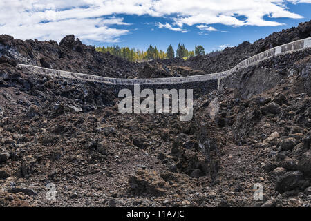 Concrete water canal through the volcanic landscape of Chinyero taking water for irrigation to the fincas in Santiago del Teide, Tenerife, canary Isla Stock Photo