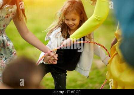 Girl playing with tire for movement training in kindergarden Stock Photo