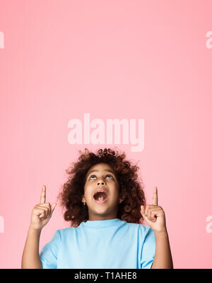 African-american girl pointing fingers up on copy space Stock Photo