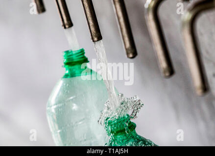 Customers get water at a source in Rome, Italy. Stock Photo