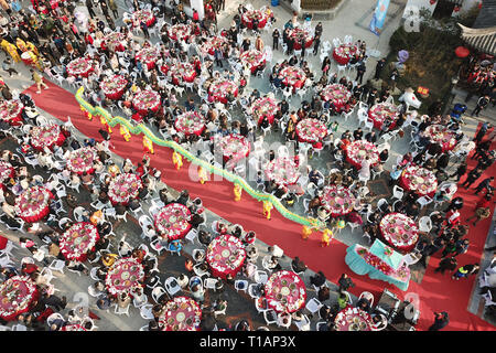 Beijing, China. 23rd Mar, 2019. Aerial photo taken on March 23, 2019 shows people getting together to taste the dishes made of Luosi, a kind of river snail, during a feast held in Jiangba Town of Hongze District of Huai'an City, east China's Jiangsu Province. Dishes of Luosi are usually sold at street stalls in China. Credit: Wan Zhen/Xinhua/Alamy Live News Stock Photo