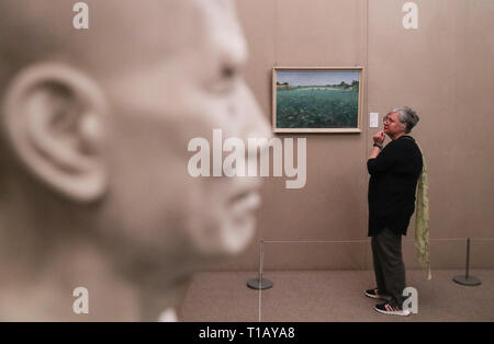Paris, France. 24th Mar, 2019. A visitor looks at artwork displayed in an exhibition marking the centennial of the Work-Study Movement in the China Cultural Center in Paris, France, March 24, 2019. A ceremony and a series of events were held here to mark the centennial of the Work-Study Movement. Starting in 1919, thousands of progressive young Chinese went to France, where they worked in factories in Paris, Lyon and Montargis to pay for their studies in the European country. Credit: Xinhua/Alamy Live News Stock Photo