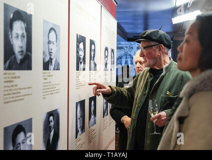 Paris, France. 24th Mar, 2019. Visitors look at photos displayed in an exhibition marking the centennial of the Work-Study Movement in the China Cultural Center in Paris, France, March 23, 2019. A ceremony and a series of events were held here to mark the centennial of the Work-Study Movement. Starting in 1919, thousands of progressive young Chinese went to France, where they worked in factories in Paris, Lyon and Montargis to pay for their studies in the European country. Credit: Xinhua/Alamy Live News Stock Photo