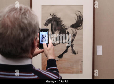 Paris, France. 24th Mar, 2019. A visitor takes photo of an exhibit displayed in an exhibition marking the centennial of the Work-Study Movement in the China Cultural Center in Paris, France, March 24, 2019. A ceremony and a series of events were held here to mark the centennial of the Work-Study Movement. Starting in 1919, thousands of progressive young Chinese went to France, where they worked in factories in Paris, Lyon and Montargis to pay for their studies in the European country. Credit: Xinhua/Alamy Live News Stock Photo