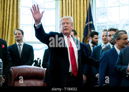 Washington, DC, USA. 25th Mar, 2019. US President Donald J. Trump (C) waves at the conclusion of a photo opportunity with players and staff of the National Hockey League (NHL) 2018 Stanley Cup Champions, the Washington Capitals; in the Oval Office of the White House in Washington, DC, USA, 25 March 2019. Credit: Michael Reynolds/Pool via CNP | usage worldwide Credit: dpa/Alamy Live News Stock Photo