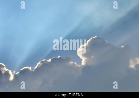 Bright line of sunbeams in cloudy sky, ray of sunlight form the sun behind cloud, beautiful cloudscape as background, cloud shape, dark cloud, sunray  Stock Photo