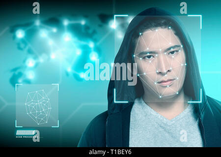 Young asian man in black hoodie using face recognition over digital world map background. Modern technology concept Stock Photo