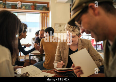 Smiling young friends reading menus in a bistro Stock Photo