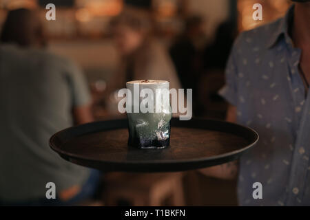 Waiter serving cocktails in a trendy bar at night Stock Photo