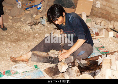 Young Uighur man lathe small piece of wood, Hotan, Xinjiang Autonomous Region, China. Stock Photo