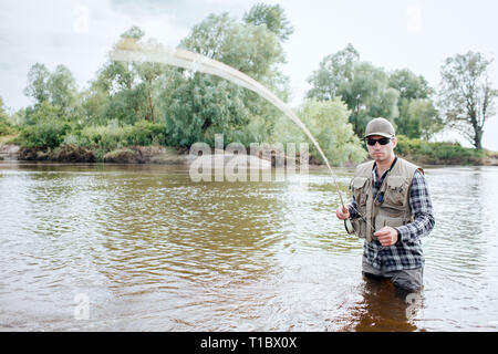Man holding fly fishing pole - Stock Image - F033/4064 - Science