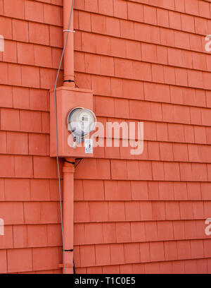 A red round digital electricity meter on cedar shingles in Charlottetown, Prince Edward Island, Canada Stock Photo