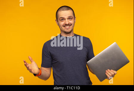 Surprised man freelancer or developer holding laptop and smiling Stock Photo
