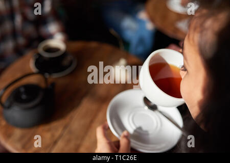 Young woman sitting in a cafe drinking tea Stock Photo