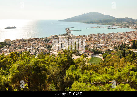 Beautiful and colorful landscape of Zakynthos in Greece. View on harbor, boats at sea and resort, with hill in the background. Zante Island. Stock Photo