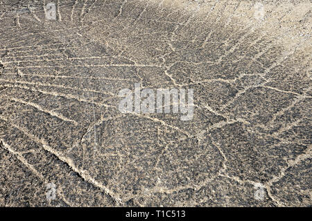 Texture of gray, cracked asphalt on road. Close up of street surface full of line cracks like a marble background. Stock Photo