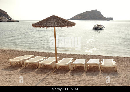 Summer seascape with view on a sea and beach, during sunny day on vacation in Greece, Zakynthos. Relax in paradise resort on sunbeds, under umbrella w Stock Photo