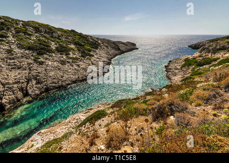 Colorful landscape wih valley between hill and island with beautiful cove. Blue sea, green mediterranean plants on hills and sunny view on horizon dur Stock Photo