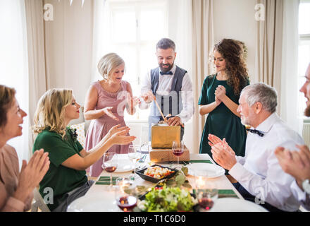 A mature man with friends and family opening presents on a birthday party. Stock Photo