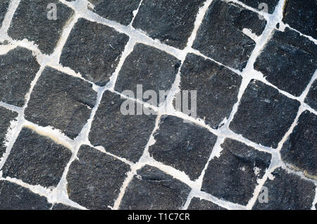 Black Granite Cobblestone Texture with White Seams. Black Chopped Cobbles Background. Stock Photo