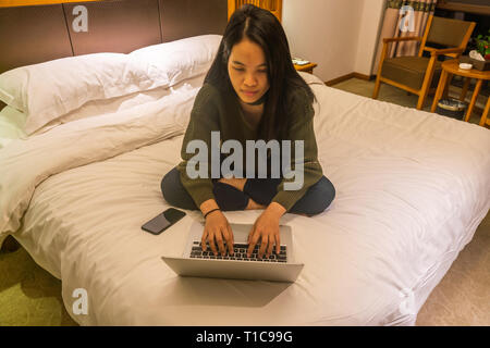 Asian woman using laptop in the hotel room Stock Photo