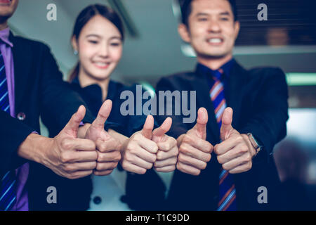 smiling happy Businessman and Businesswomen celebrating success Achievement Arm Raised and show thumb up Concept Stock Photo