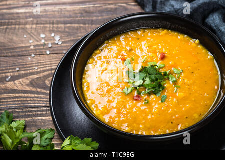 Red lentil soup in black bowl. Stock Photo