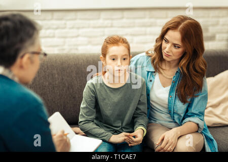 Sad cheerless red haired girl feeling stressed Stock Photo