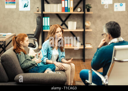 Nice young woman having a conversation with her therapist Stock Photo