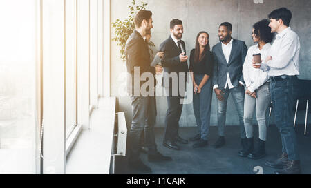 Colleagues talking at coffee break near window Stock Photo