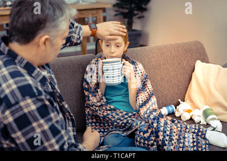 Sad cheerless girl having her hot tea Stock Photo