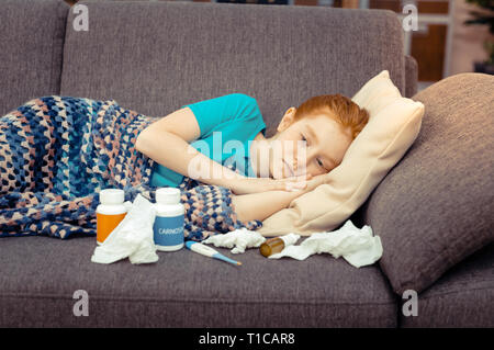 Sad girl lying on a sofa at home Stock Photo - Alamy