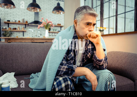Unhappy ill man having a strong cough Stock Photo