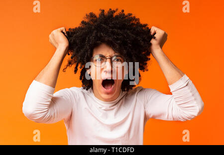Emotional black man in despair pulling out his hair Stock Photo