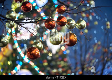 Christmas balls on a tree. On the background in the defocus of the Christmas tree with lights. Stock Photo