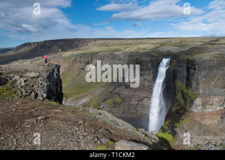 Beautiful view of Haifoss waterfall with adventure woman - Iceland Stock Photo