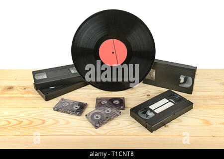 Composition of vinyl disc, audiocassettes and videocassettes on wooden table. Copy space Stock Photo