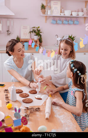 Joyful females decorating cookies together with pleasure Stock Photo