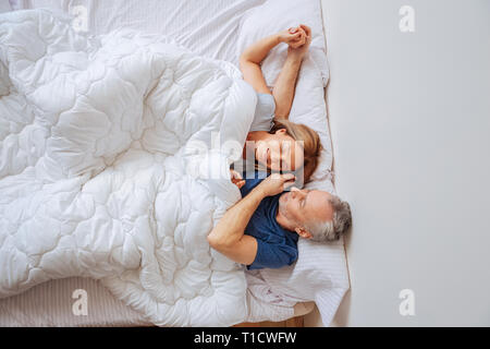 Man and woman feeling relaxed while lying in bed in the morning Stock Photo