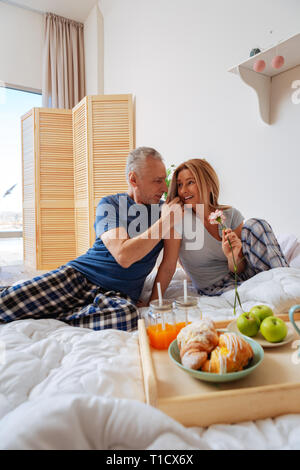 Mature couple enjoying romantic morning having breakfast in bed Stock Photo