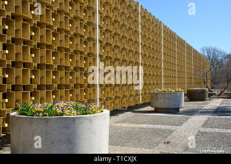 Irregular pattern aluminum wall with large concrete flower pot in front Stock Photo